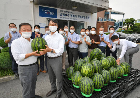 현대모비스가 A/S 부품 우수 협력사 중 한 곳인 우진공업에 계절 과일을 선물하고 있다. 사진은 박종원 현대모비스 통합구매실 상무(왼쪽 첫 번째)와 우진공업 류시혁 대표이사.(왼쪽 두 번째)<현대모비스 제공>